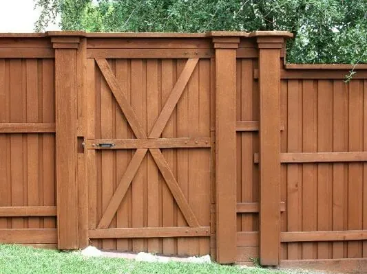 Stained wood privacy fence with a double gate