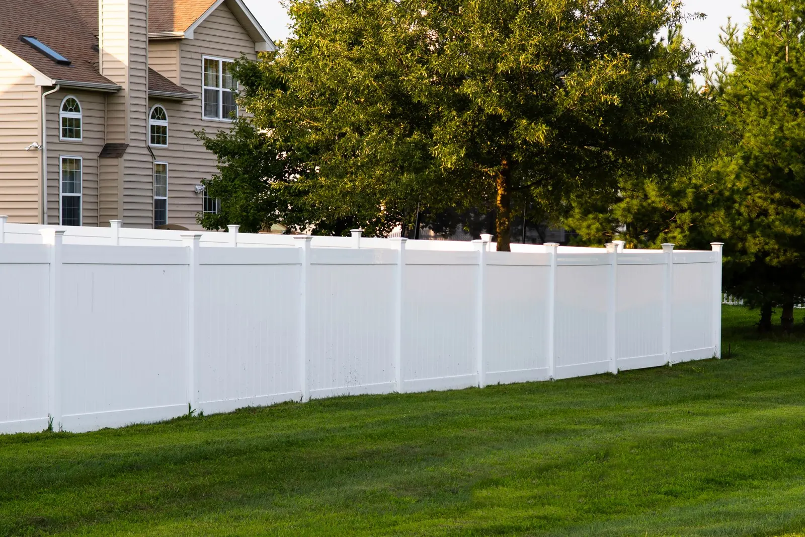White vinyl privacy fence beside a home