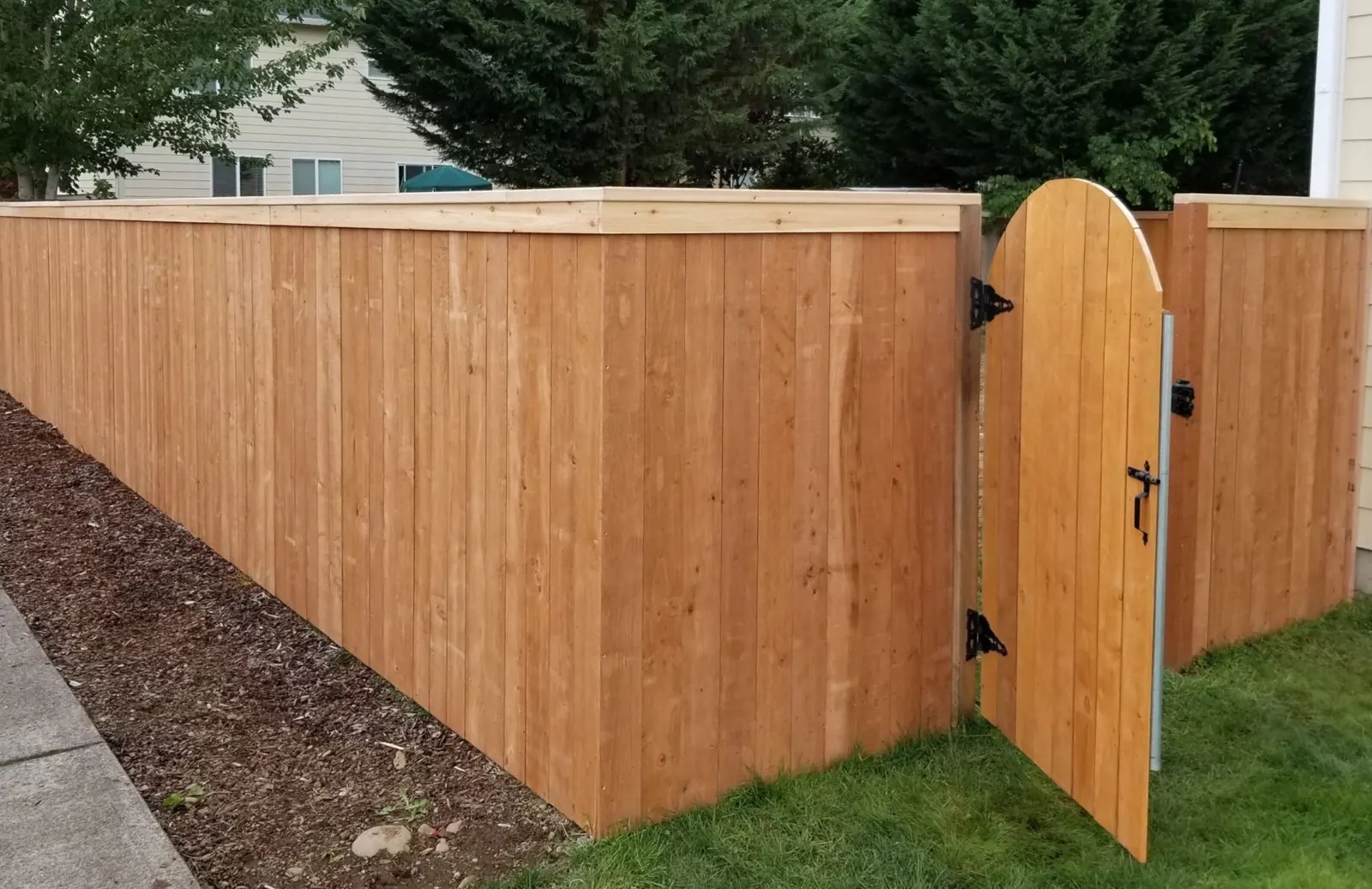 Cedar wood privacy fence with an arched-top walk gate